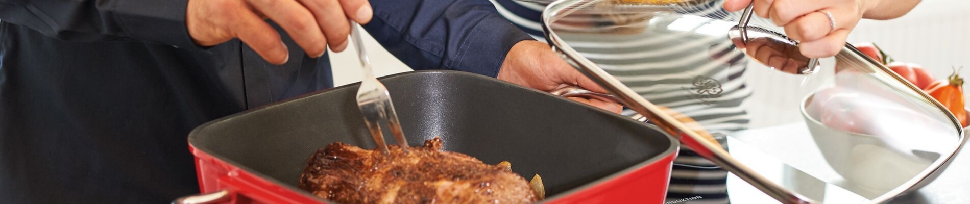Aluminium Bratpfanne und Deckel auf einem Herd mit einem Stück Fleisch